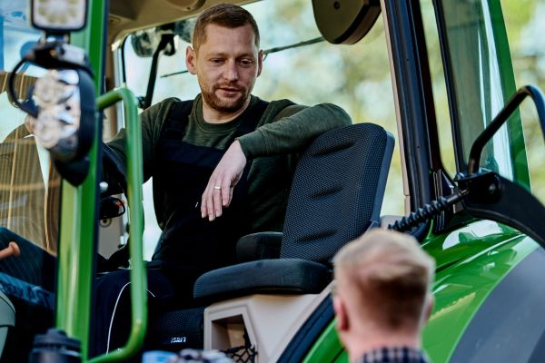 Rückengesunde Sitze für Baumaschinen Mann sitzt in Traktor, Link führt zu Seite mit Infos über rückengesunde Sitze für Baumaschinen.