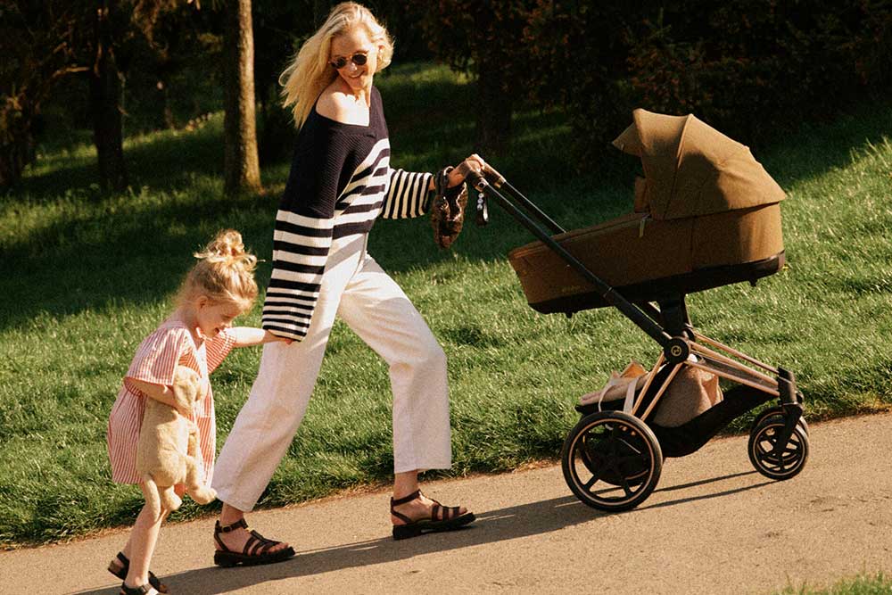 Kinderwagen und Buggys Frau mit Kinderwagen und neben ihr ein Kleinkind an der Hand. Link zu Kinderwagen und Buggys