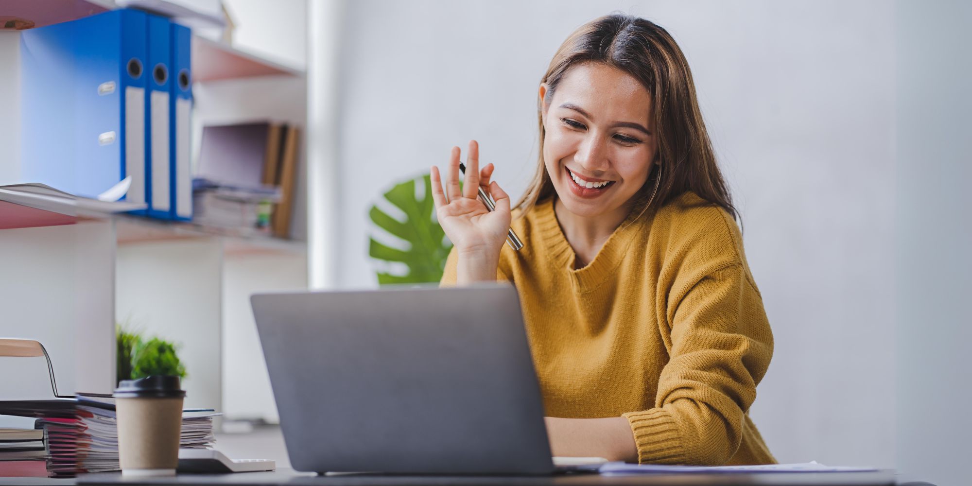 Frau arbeitet lächelnd am Laptop – Übersicht der Online-Seminare zur Rückengesundheit